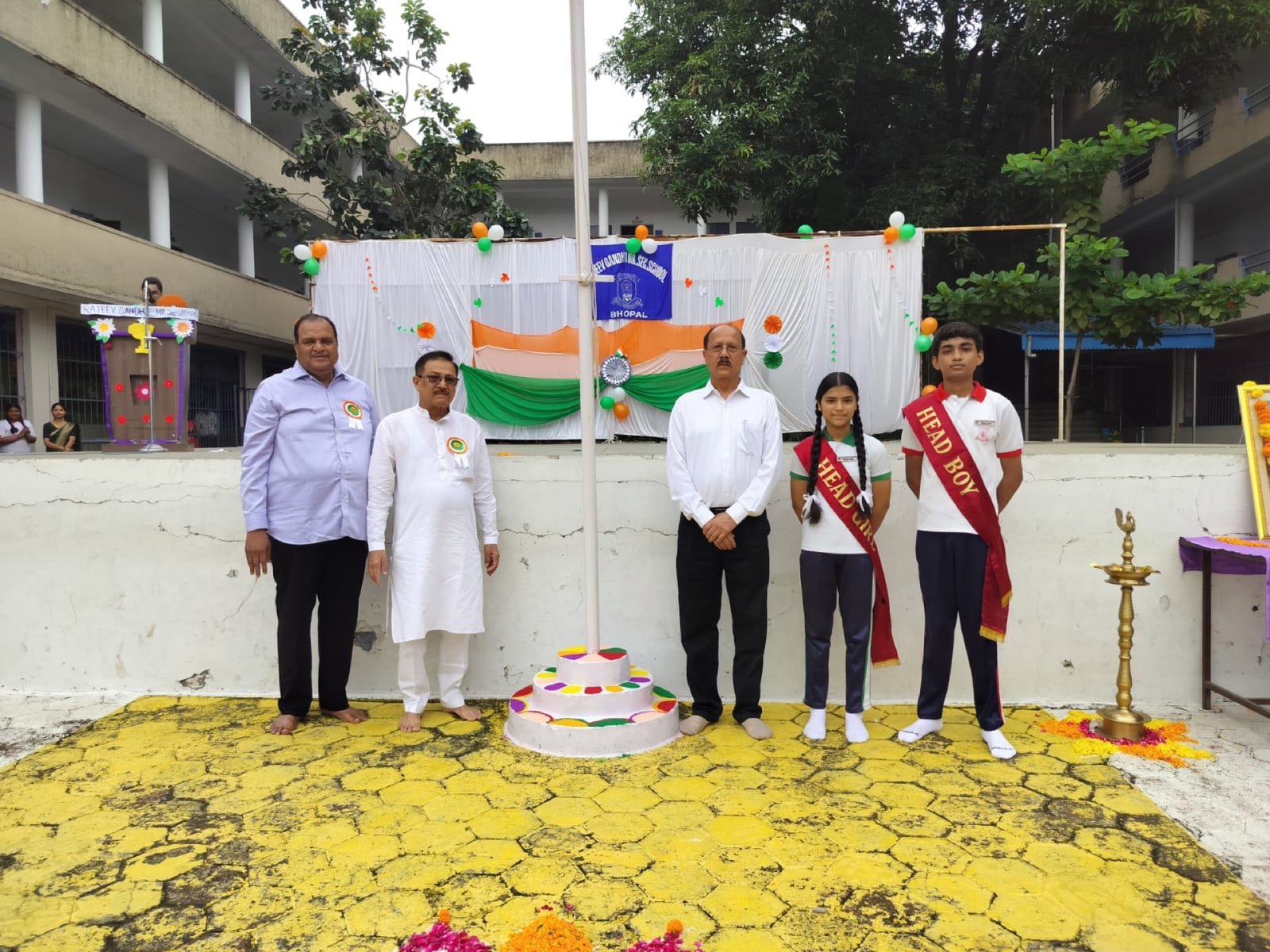 School management and student leaders at an Independence Day flag-hoisting ceremony
